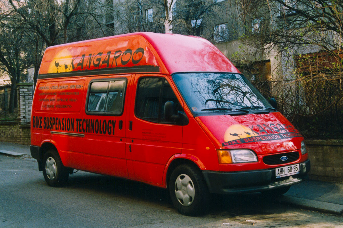 Červený Ford Kangaroo, loga a texty černá a žlutá Polepený červený Ford Transit firmy Kangaroo výrobce odpružených vidlic