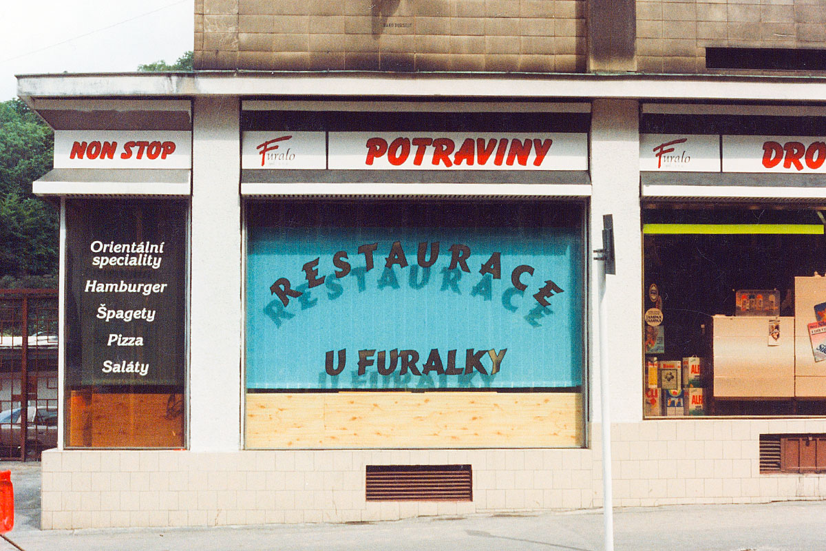 Zlatý nápis restaurace U Furalky Nápisy bílé, červené a zlaté s černou konturou