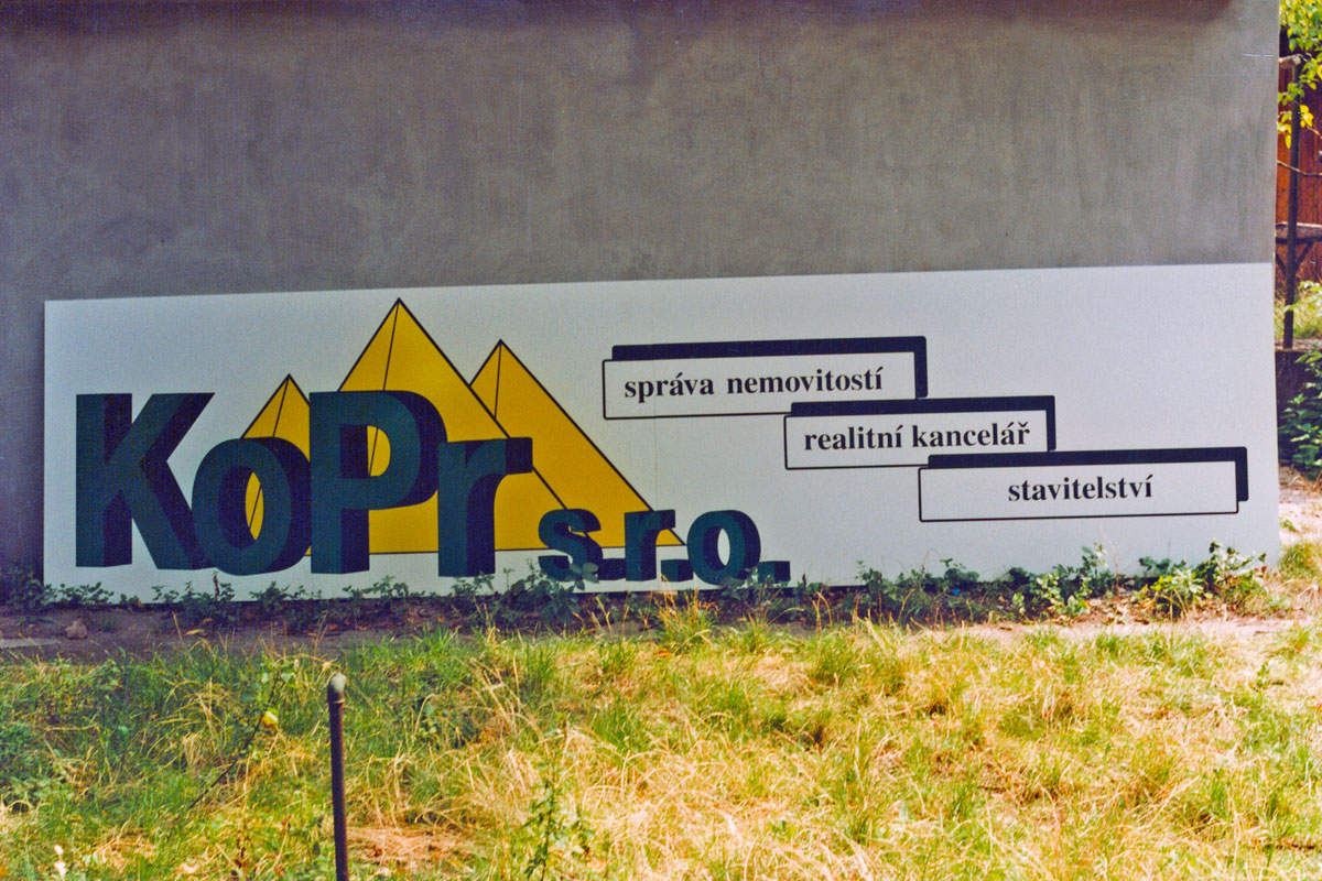 Logo Kopr a reklamní text na desce před instalací na dům Desky s logem Kopr před instalací na dům, desky Simona Coplast AS 10 mm, řezaná reklama